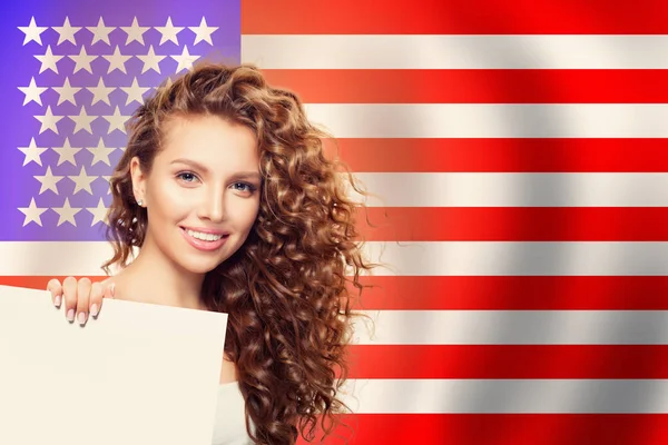 Happy american girl with white paper against the USA flag — Stock Photo, Image