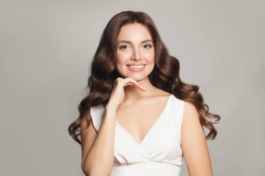 Güzel, zarif, mutlu, uzun, sağlıklı saçlı, gülümseyen bir kadın.