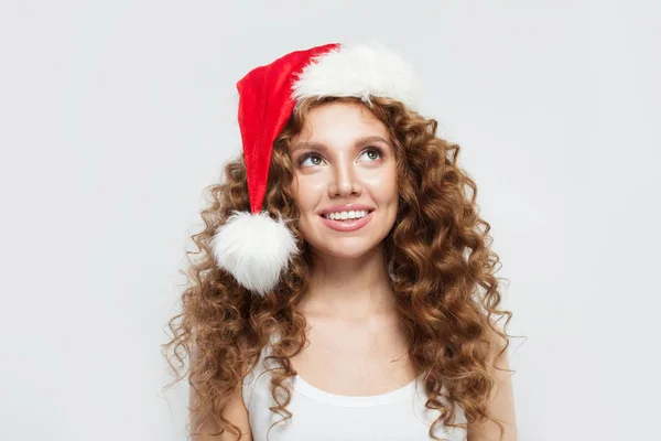 Glad glad ung kvinna i tomte hatt ler. Jul- och nyårsfest — Stockfoto