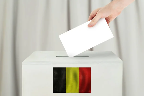 Belgian Vote concept. Voter hand holding ballot paper for election vote on polling station