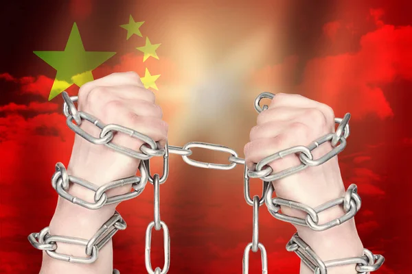 Two hands shackled a metal chain on China  flag. Freedom concept