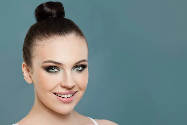 Happy woman, female face close up on blue background