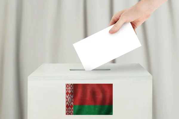 ベラルーシの投票コンセプト 投票所での投票のための投票用紙を保持する投票手 — ストック写真