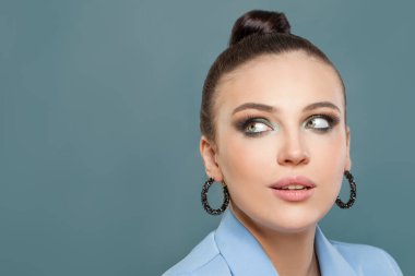 Mavi arka planda zarif esmer kadın. Mükemmel yüz kapanışı