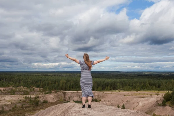 Carefree woman against sky clouds outdoors