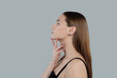 Genç bir kadın yüzü. Temiz ciltli ve düz saçlı sağlıklı bir model.