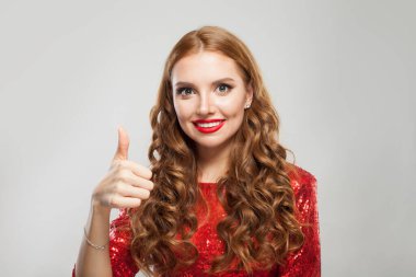 Güzel bir kadın beyaz arka planda baş parmağını gösteriyor.