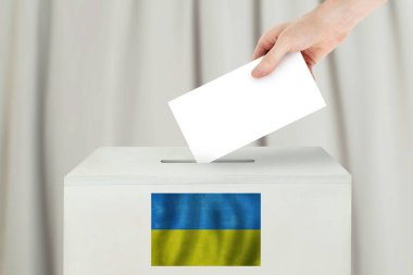 Ukrayna oylama konsepti. Seçim sandığı için oy pusulası tutan seçmen.