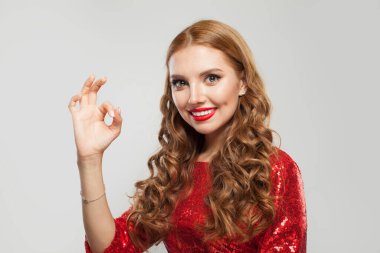 Kızıl saçlı kadın beyaz arka planda iyi niyet gösterisi yapıyor.