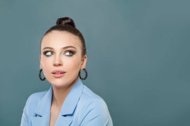 Çekici bir kadın mavi arka plana bakıyor.