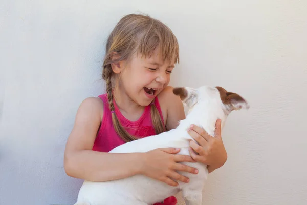 Mutlu Çocuk Beyaz Duvara Karşı Köpeği Tutuyor — Stok fotoğraf