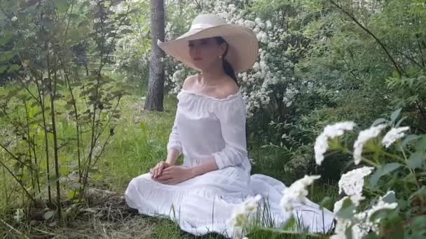 戴着帽子的优雅女人 坐在户外开着夏天的花 — 图库视频影像