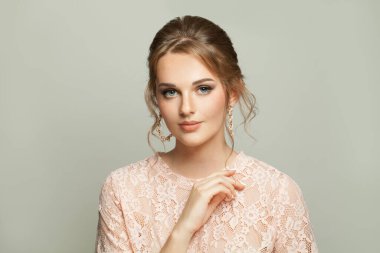 Çekici bir kadın, beyaz arka planda güzel saç şekli ve pastel makyajı var.