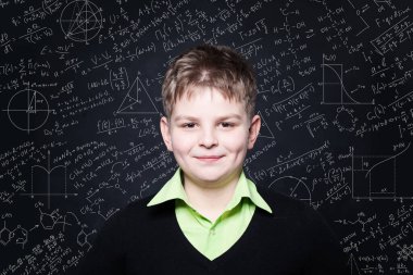 Sınıfta tahtada gülümseyen bir çocuk. Eğitim ve okul konseptine dönüş