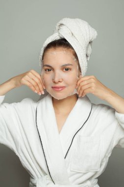 Pretty woman taking care of her skin wearing sheet mask. Skin care and hydration concept