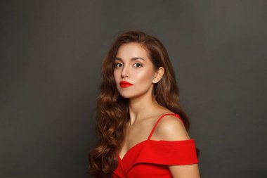 Gorgeous woman with long hair and make-up on black background. Gorgeous woman with curly hairstyle