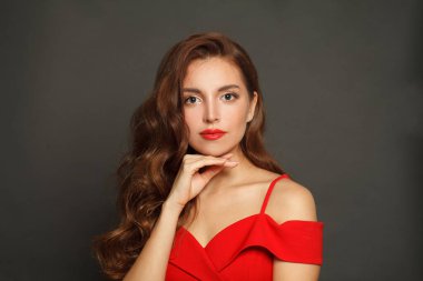 Nice woman with long hair and make-up on black background. Gorgeous woman with curly hairstyle