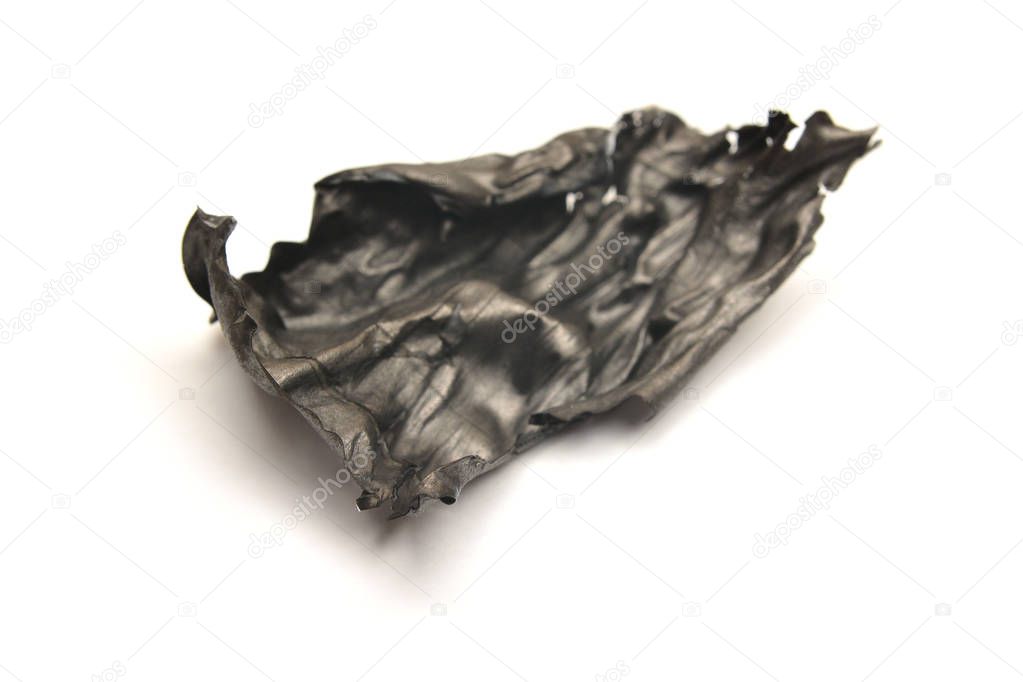 a piece of burnt paper, ashes on white background