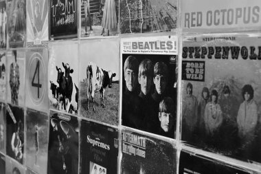 Atina, Yunanistan - 29 Ağustos 2018: Vintage vinil kayıtlar pop ve rock müzik albümü ile duvar arka plan hortumlar. Seçici odak siyah ve beyaz.