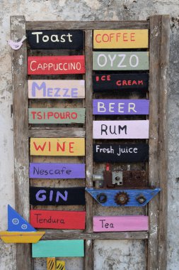 Zakynthos, Yunanistan - 14 Ağustos 2018: Menü Yönetim Kurulu işareti ile el yapımı dekoratif tekneler ahşap cafe bar içecekler.