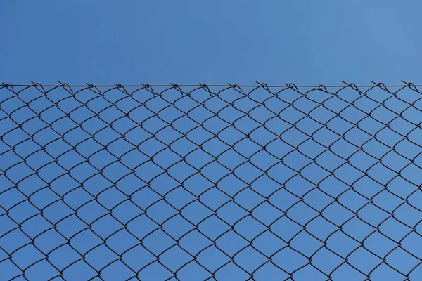 Rostiger Maschendrahtzaun und blauer Himmel — Stockfoto