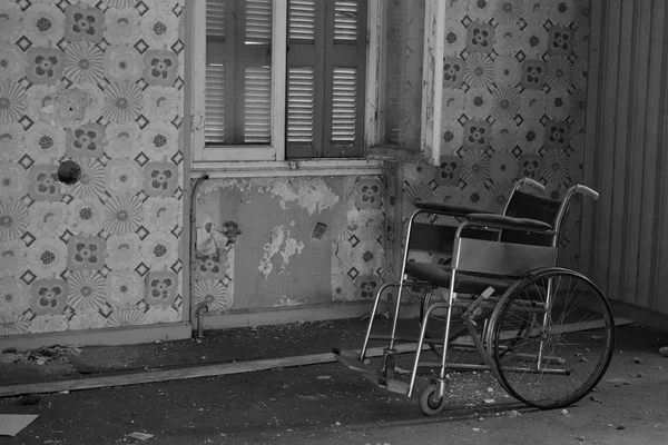 Cadeira de rodas antiga em casa abandonada — Fotografia de Stock