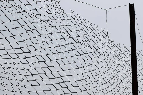 Damaged barbed wire chain link fence — Stock Photo, Image