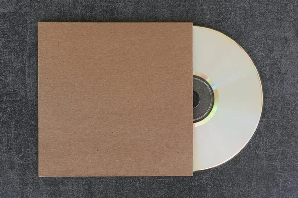 空白白色标签Cd盘和通用的褐色纸板袖子与复制空间覆盖您的设计 免版税图库照片