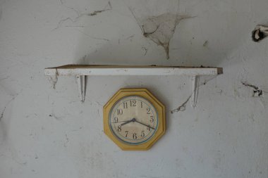Terk edilmiş evde örümcek ağlı eski tozlu saat ve duvar.