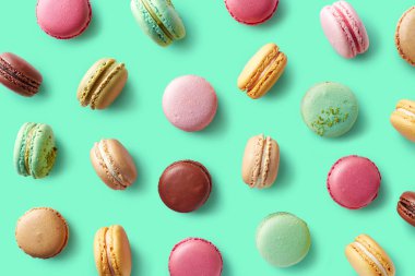 Mavi arka plan üzerinde renkli Fransız macarons deseni. Üstten görünüm. Pastel renkler
