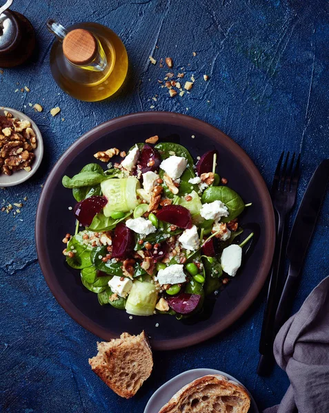 新鮮な健康野菜と青の背景にほうれん草 キュウリ ビート フェタ チーズとキノアのサラダのプレート トップ ビュー — ストック写真