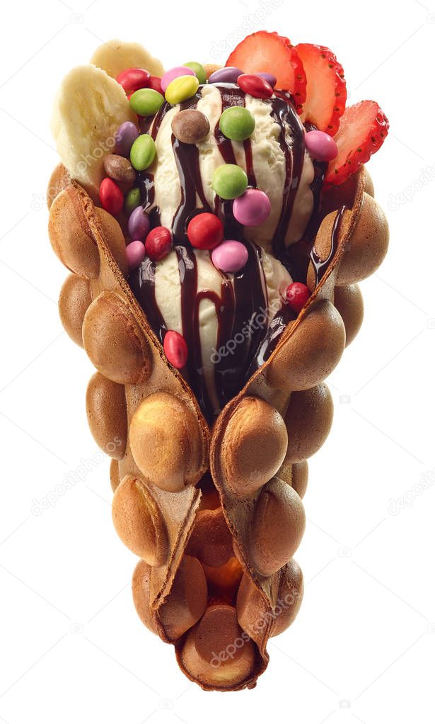 Hong kong or bubble waffle with ice cream, fruits, chocolate sauce and colorful candy isolated on white background