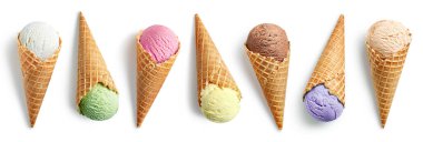 Beyaz arka planda izole edilmiş waffle külahlarında farklı dondurma kepçeleri. Vanilya, fıstık, çilek, karamel, mango, yabanmersini ve çikolata aromalı.