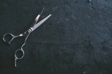 Kuaför makası boşaltmak yukarıdan rustik koyu zemin üzerine. Profesyonel saç modeli salon stüdyo arka plan tasarımı. Siyah saç kesimi aracının üstten görünüm.