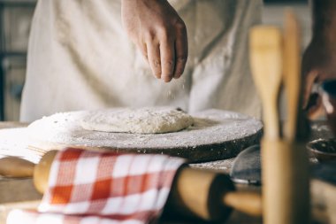 Yoğurma ve ev yapımı pizza hamuru mutfak pişirme dostum. Baker'ın closeup hazırlanıyor somun ekmek eller. Evde yemek ve gıda hazırlama.