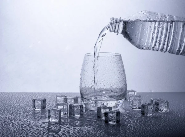 Выливание Пресной Минеральной Воды Пластиковой Бутылки Стекло Заполнено Водой Белом — стоковое фото