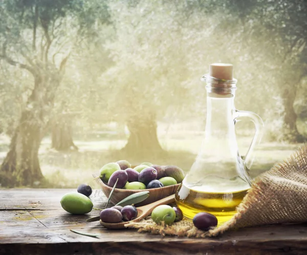橄榄园的木桌上加了橄榄和一瓶特级的橄榄油 传统自制橄榄油和橄榄树背景阳光 — 图库照片