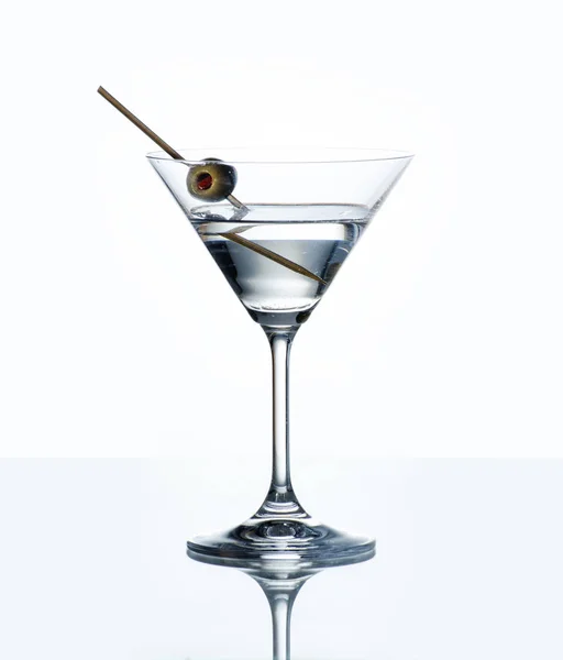 反射で白い背景の上のカクテル グラス グリーン オリーブとドライマティーニ バーのカウンターで高級アルコール ドリンク — ストック写真