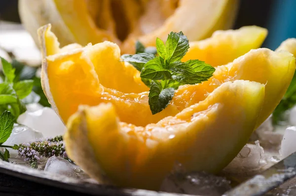 Nahaufnahme von Cantaloupe-Melonenscheiben mit Minze und Eis serviert auf — Stockfoto