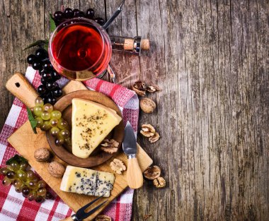 Rustik ahşap masa ba kırmızı şarap, üzüm ve peynir üst görünümü