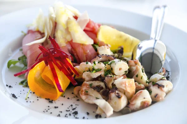 Salade de fruits de mer servie dans une assiette blanche en gros plan. Poulpe et thon fi — Photo