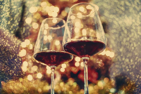 Zwei Glas Rotwein vor dem Weihnachtsbaumbeleuchtung bokeh. n — Stockfoto
