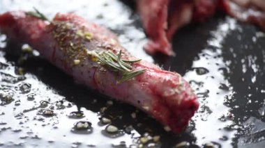 Kuzu eti bbq hazırlığı. Baharatlı kuzu pirzolası ve siyah kırsal tabakta biberiye..