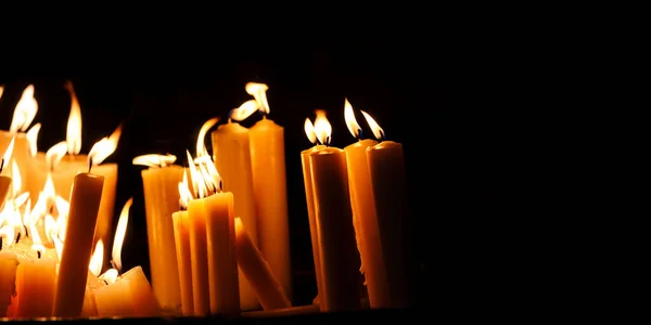 黒の背景に宗教的なろうそくの光 夜の暗いキリスト教会で黄色いろうそくの炎 キリスト教の信仰 — ストック写真