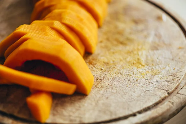 Butternut squash meal preparation on wooden kitchen table. Cooking food for traditional thanksgiving dinner. Making autumn pumpkin soup.