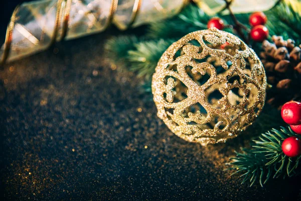 暗いヴィンテージテーブルの上に黄金のクリスマスの飾り モミの木と金のリボンでクリスマスの贅沢はまだ生活 大晦日のための豪華な家の装飾の閉鎖 冬休みグリーティングカードの背景 — ストック写真