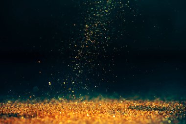 Lüks, soyut, ışıltılı, gösterişli bir arka plan. Yeni yıl ve noel partisi tasarımı. Koyu arkaplanda parıldayan altın yıldız tozu ışığı.