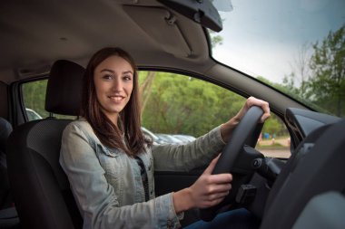 güzel kız bir arabanın direksiyonuna oturur