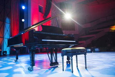 Sahne ışıkları altında piyano. Konserden önce.