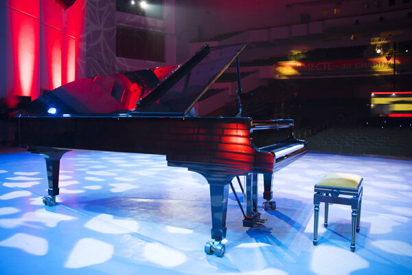 the piano on stage in the spotlight. Before the concert